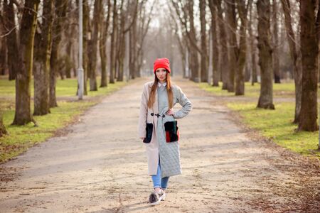 Beautiful girl in a red cap walks through the cityの写真素材