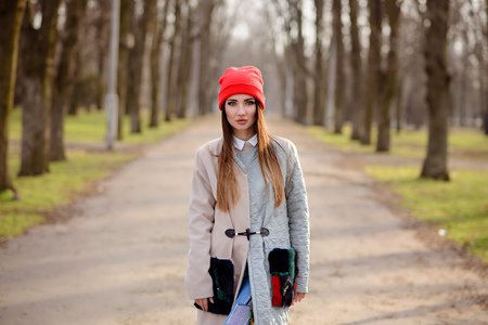 Beautiful girl in a red cap walks through the cityの写真素材