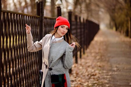 Beautiful girl in a red cap walks through the cityの写真素材