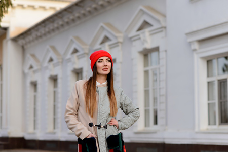 Beautiful girl in a red cap walks through the cityの写真素材