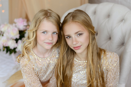 Two beautiful girls in a studio. They wear light beautiful dresses. Both are blond.の写真素材