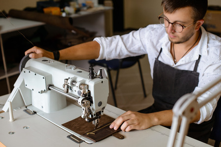 Leather handbag craftsman at work in a workshop