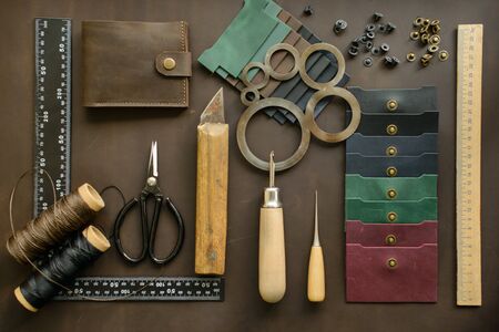 Leathersmith's work desk. Leather working tools on a work tableの写真素材