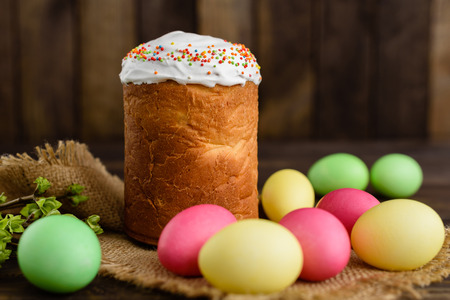 Easter cake and colorful eggs on a wooden table. It can be used as a background