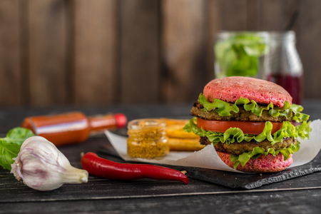 Tasty hamburger with meat and vegetables against a dark background.の写真素材