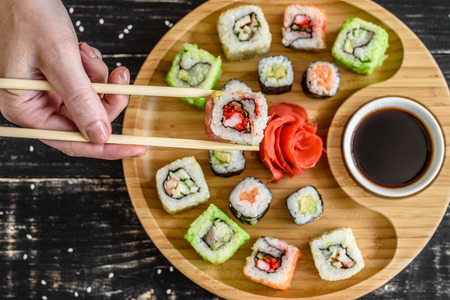 Fresh and tasty sushi on dark background. It can be used as a backgroundの写真素材