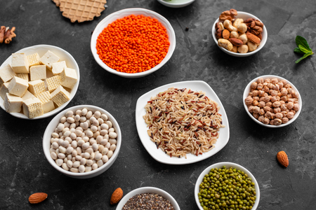 Healthy vegan food background with copy space. Nuts, beans, greens and seedsの写真素材