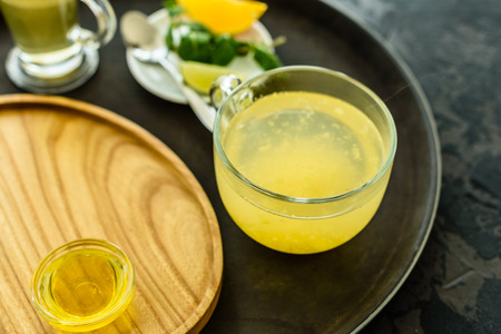 Tea with sea buckthorn in glass and honey. It can be used as a backgroundの写真素材
