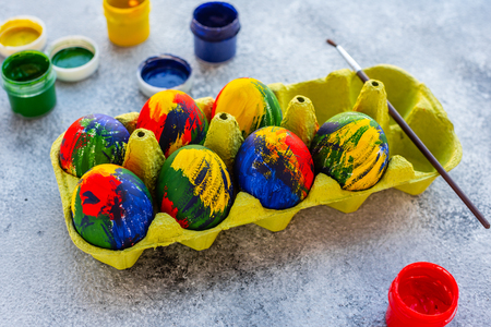 Easter multi-colored eggs, paints and brush on a table. Preparation for a holidayの写真素材