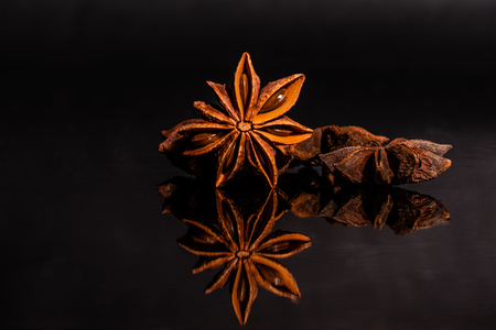 Star anise against a dark background. Spice on a glass background with reflectionの写真素材