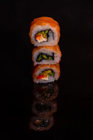 Fresh and tasty sushi on dark background. It can be used as a backgroundの写真素材
