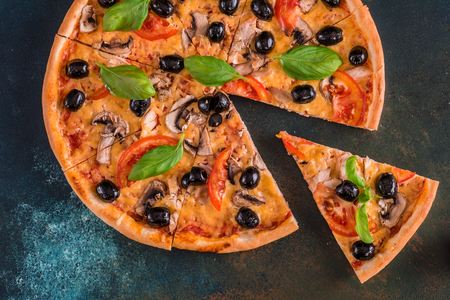 Tasty fresh hot pizza against a dark background. Pizza, food, vegetable, mushroomsの写真素材