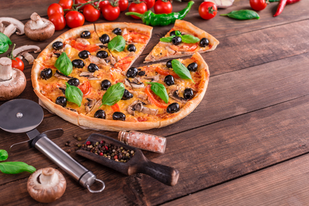 Tasty fresh hot pizza against a dark background. Pizza, food, vegetable, mushrooms. It can be used as a backgroundの写真素材