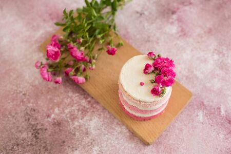 Beautiful pink cream and berries cake on a light concrete background. Birthday celebrationの写真素材