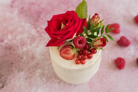 Beautiful pink cream and berries cake on a light concrete background. Birthday celebrationの写真素材