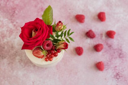 Beautiful pink cream and berries cake on a light concrete background. Birthday celebrationの写真素材