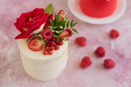 Beautiful pink cream and berries cake on a light concrete background. Birthday celebrationの写真素材