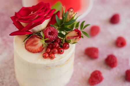 Beautiful pink cream and berries cake on a light concrete background. Birthday celebrationの写真素材
