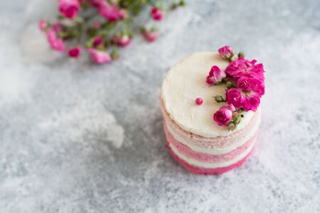 Beautiful pink cream and berries cake on a light concrete background. Birthday celebrationの写真素材