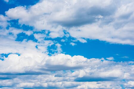 Beautiful white cumulonimbus clouds against the background of the bright blue sky