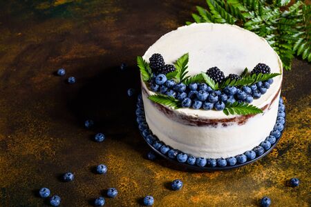 Beautiful tasty cake with white cream and berries of blueberry