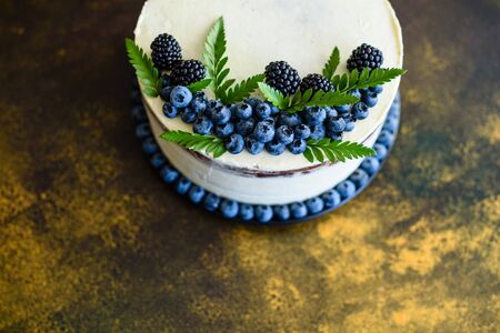 Beautiful tasty cake with white cream and berries of blueberry