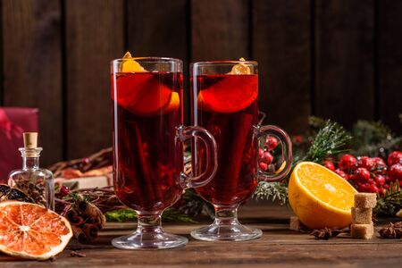 Christmas hot mulled wine with cinnamon cardamom and anise on wooden backgroundの写真素材