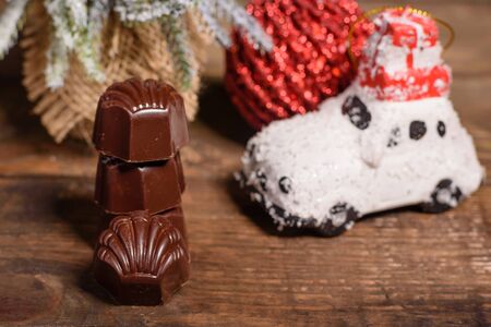 Assortment of fine chocolate candies, white, dark, and milk chocolate sweets background. Christmas interior with gift boxes and Christmas firesの写真素材