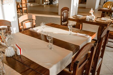 Glasses, flower fork, knife served for dinner in restaurant with cozy interior. Empty glasses in restaurantの写真素材