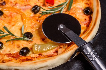 Tasty fresh hot pizza against a dark background. Pizza, food, vegetable, mushrooms.  It can be used...