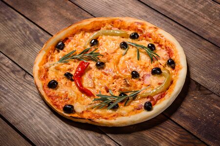 Tasty fresh hot pizza against a dark background. Pizza, food, vegetable, mushrooms.  It can be used as a backgroundの写真素材