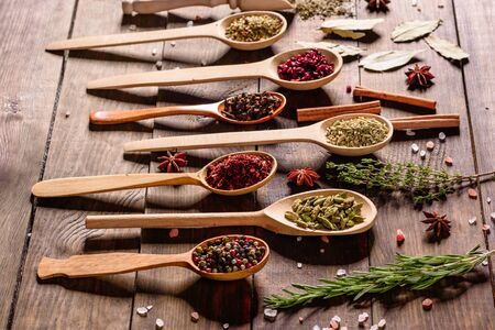 A set of spices and herbs. Indian cuisine. Pepper, salt, paprika, basil and other on a dark background. Top view. Free copy space.の写真素材