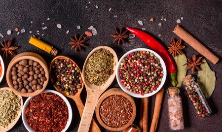 A set of spices and herbs. Indian cuisine. Pepper, salt, paprika, basil and other on a dark...