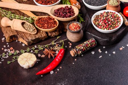 A set of spices and herbs. Indian cuisine. Pepper, salt, paprika, basil and other on a dark background. Top view. Free copy spaceの写真素材