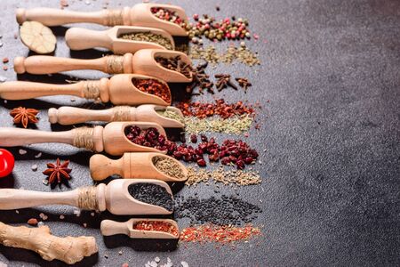 A set of spices and herbs. Indian cuisine. Pepper, salt, paprika, basil and other on a dark background. Top view. Free copy spaceの写真素材