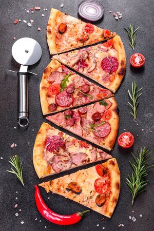 Pepperoni Pizza with Mozzarella cheese, salami, ham. Italian pizza on a dark backgroundの写真素材