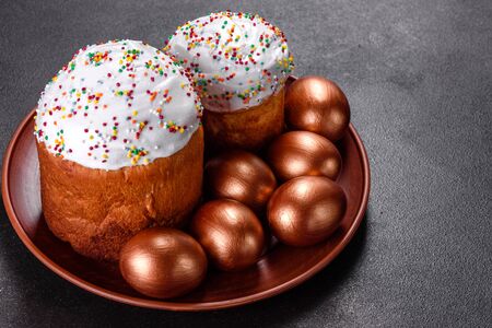 Easter eggs gold and bronze and Easter cake on a dark background. Preparation for the holiday