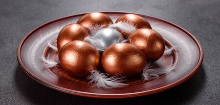 Easter eggs gold and bronze and Easter cake on a dark background. Preparation for the holiday