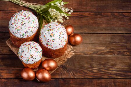 Easter eggs gold and bronze and Easter cake on a dark background. Preparation for the holiday
