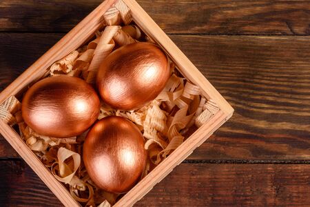 Easter eggs in gift wooden box on dark wooden background. Preparation for the holidayの写真素材