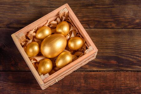 Easter eggs in gift wooden box on dark wooden background. Preparation for the holidayの写真素材