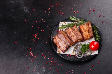 Fried ribs with rosemary, onion, sauce on a concrete background. Dark table. Place for text, copyspaceの写真素材