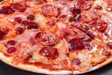 Pepperoni pizza with mozzarella cheese, salami, tomatoes, pepper and spices. Italian cuisineの写真素材