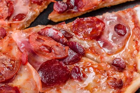 Pepperoni pizza with mozzarella cheese, salami, tomatoes, pepper and spices. Italian cuisineの写真素材