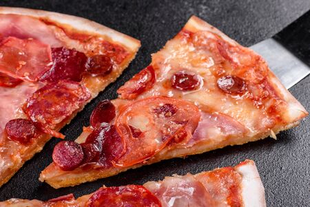 Pepperoni pizza with mozzarella cheese, salami, tomatoes, pepper and spices. Italian cuisineの写真素材