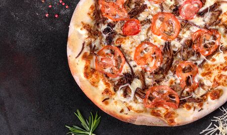 Fresh hot pizza with meat, mushrooms, cheese and tomatoes made in an oven. Italian cuisineの写真素材