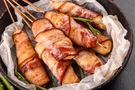 Roll with bacon and chicken mince on a stew with fresh asparagus and spicesの写真素材
