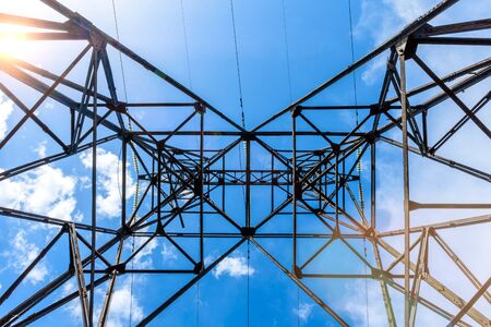 High voltage electric pillar from under. A high-voltage electricity tower. A High-voltage power...