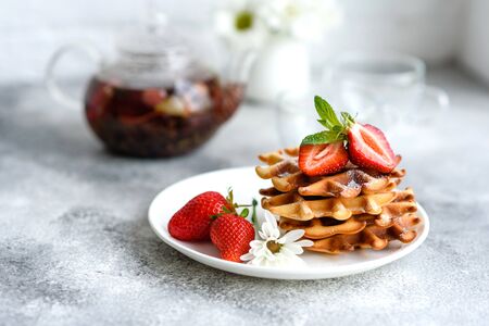 Delicious fresh baked belgian waffles with berries and fruit on a concrete backgroundの写真素材