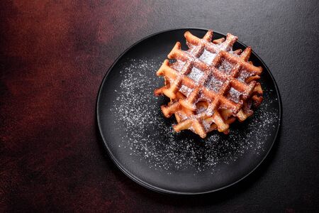 Delicious fresh baked belgian waffles with berries and fruit on a concrete background